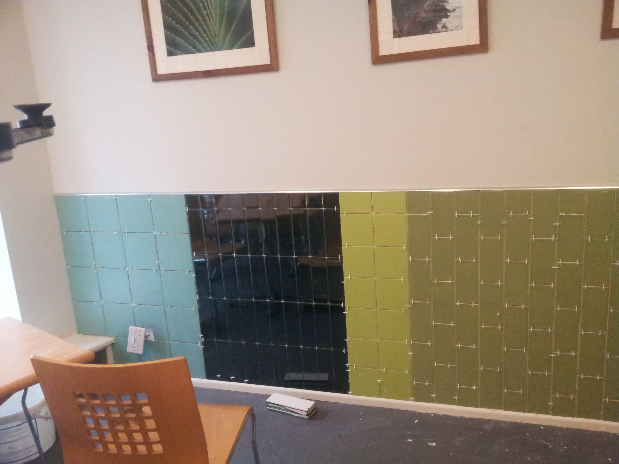 The beginning of the installation, with the main colour sections and different tile formats already taking shape. Tile spacers ensure consistent and precise joints throughout the wall.