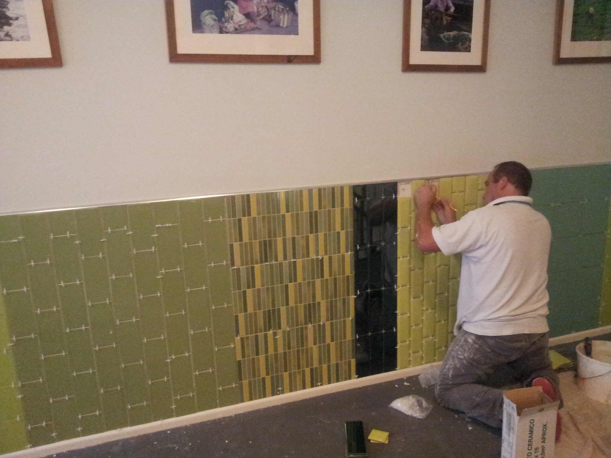 Installation of the textured and patterned tiles. Careful positioning was essential to maintain clean lines while combining several different tile styles.