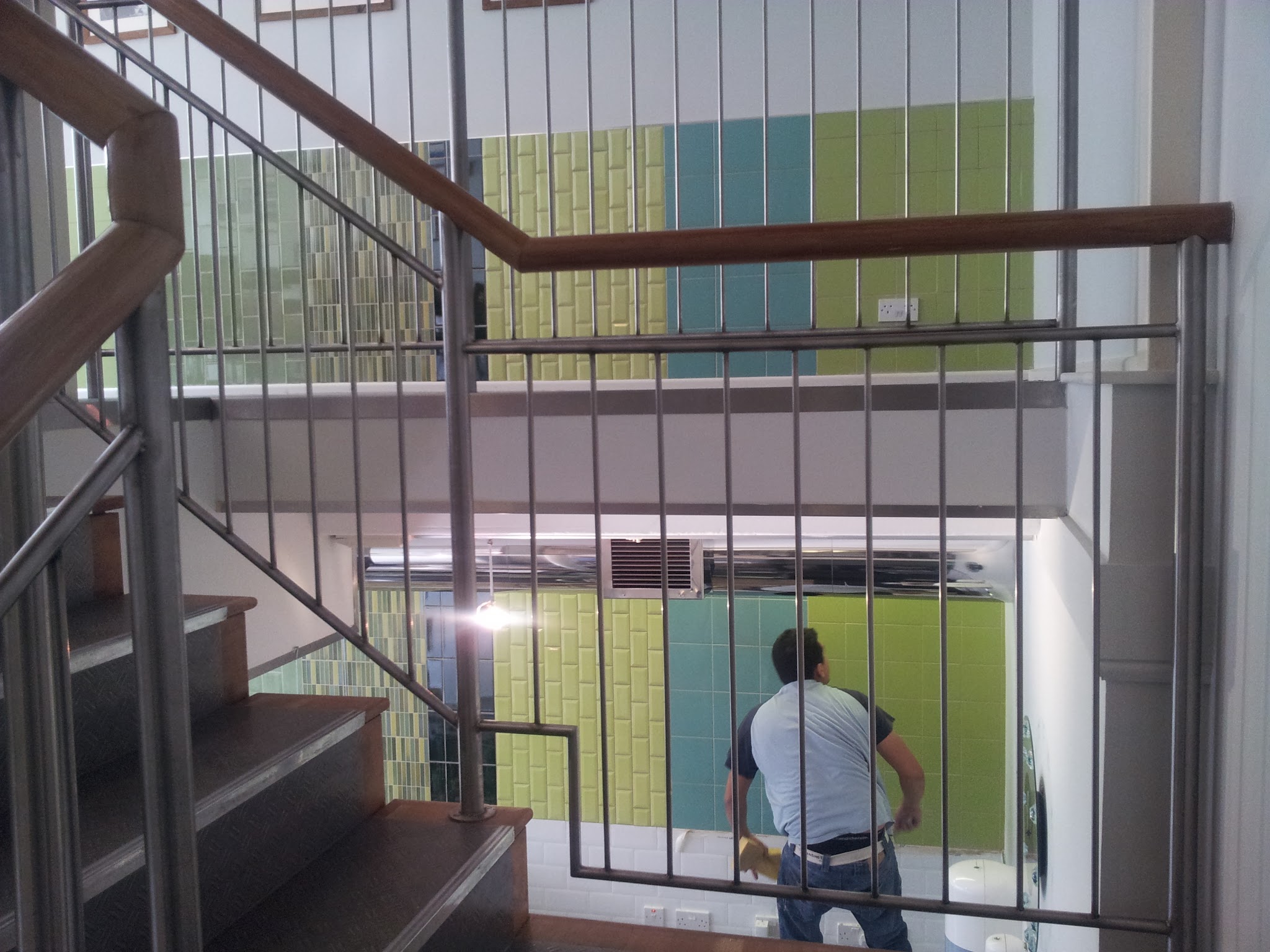 Le mur carrelé vu depuis le niveau supérieur montre comment le décor se prolonge dans le café et s’intègre à l’architecture du lieu.