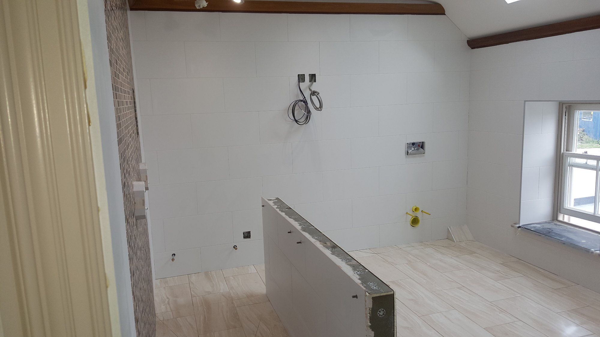 The main bathroom walls were finished with clean white tiles, complemented by warm stone-effect floor tiles.