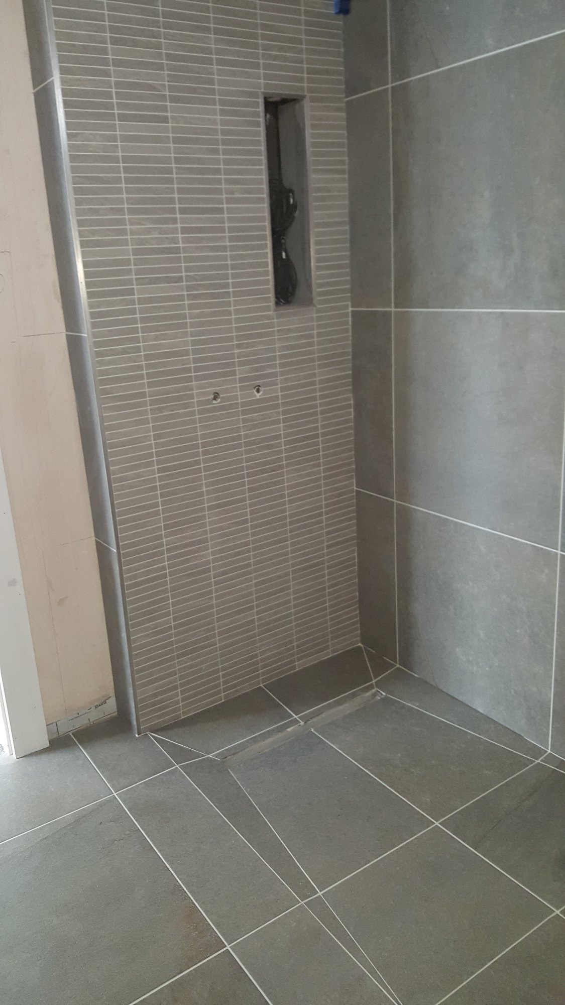 The walk-in shower floor and feature wall were carefully tiled, with a recessed storage niche incorporated into the design.