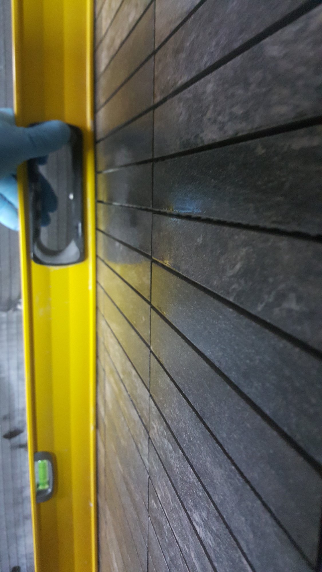 The alignment and level of the narrow feature tiles were carefully checked to ensure a perfectly even finish.