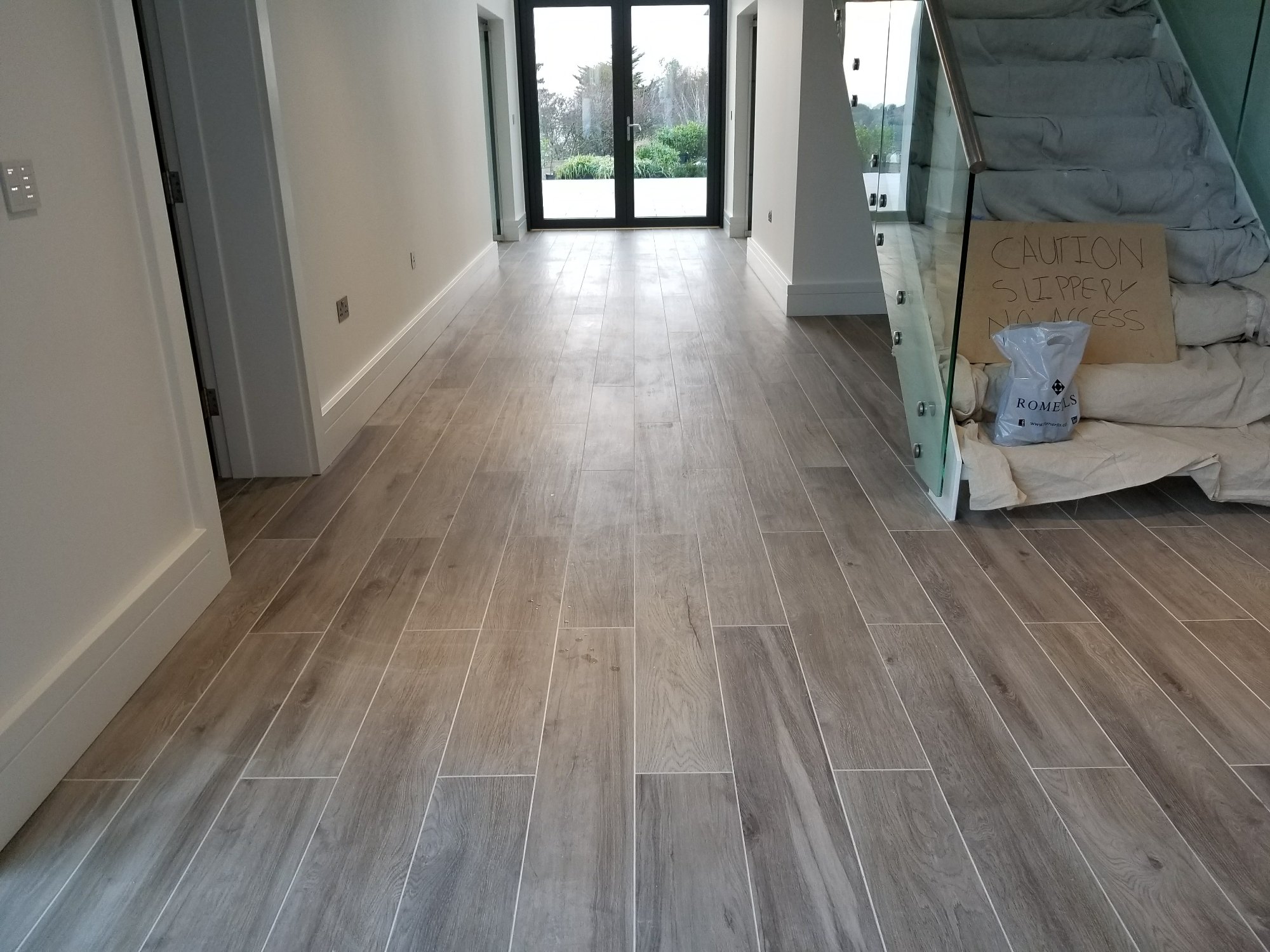 The finished tiled floor runs seamlessly through the hallway, creating a clean and welcoming entrance.